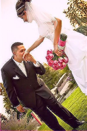 Bride kissing groom's hand outdoors